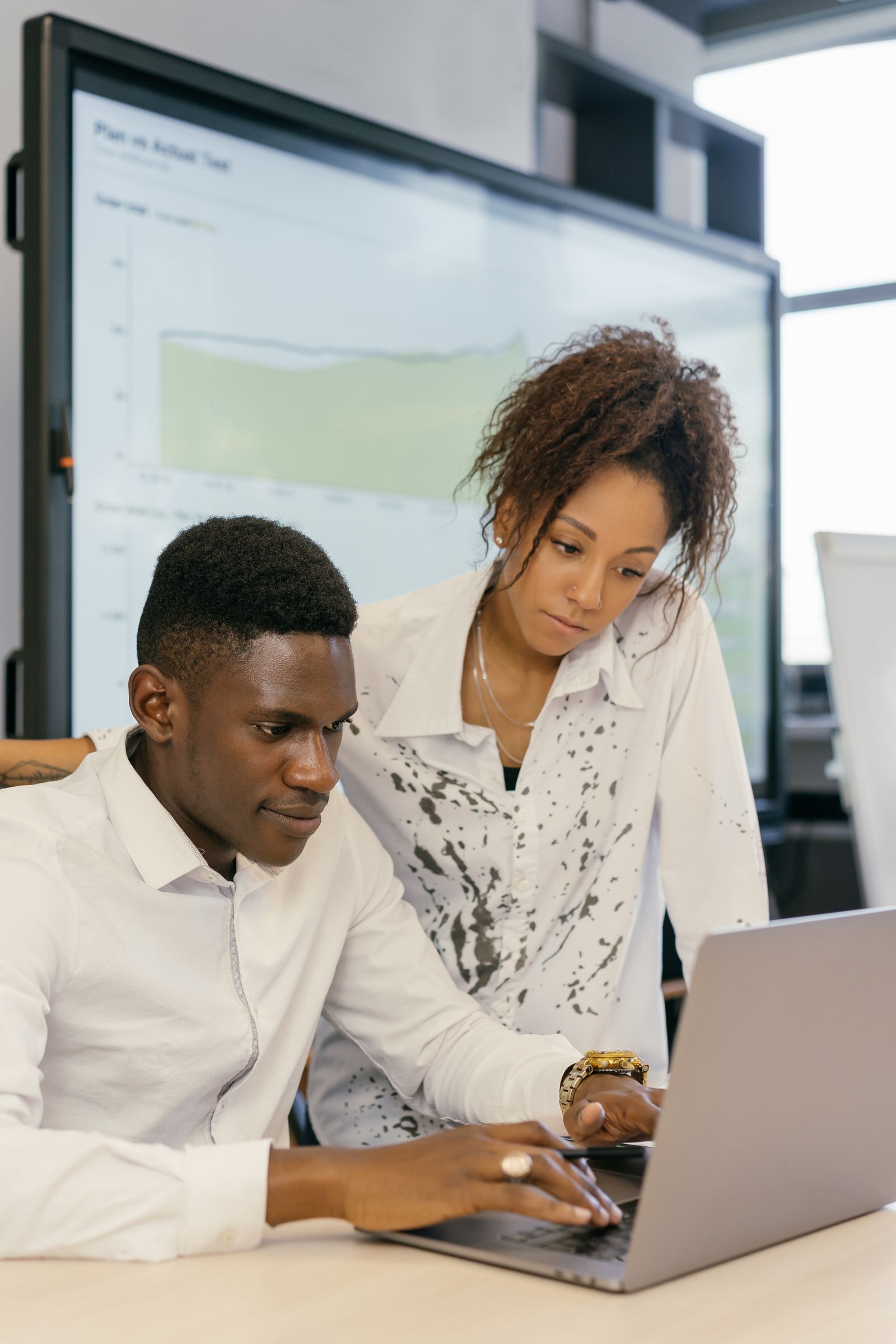 Dos personas revisan una tarea en una computadora